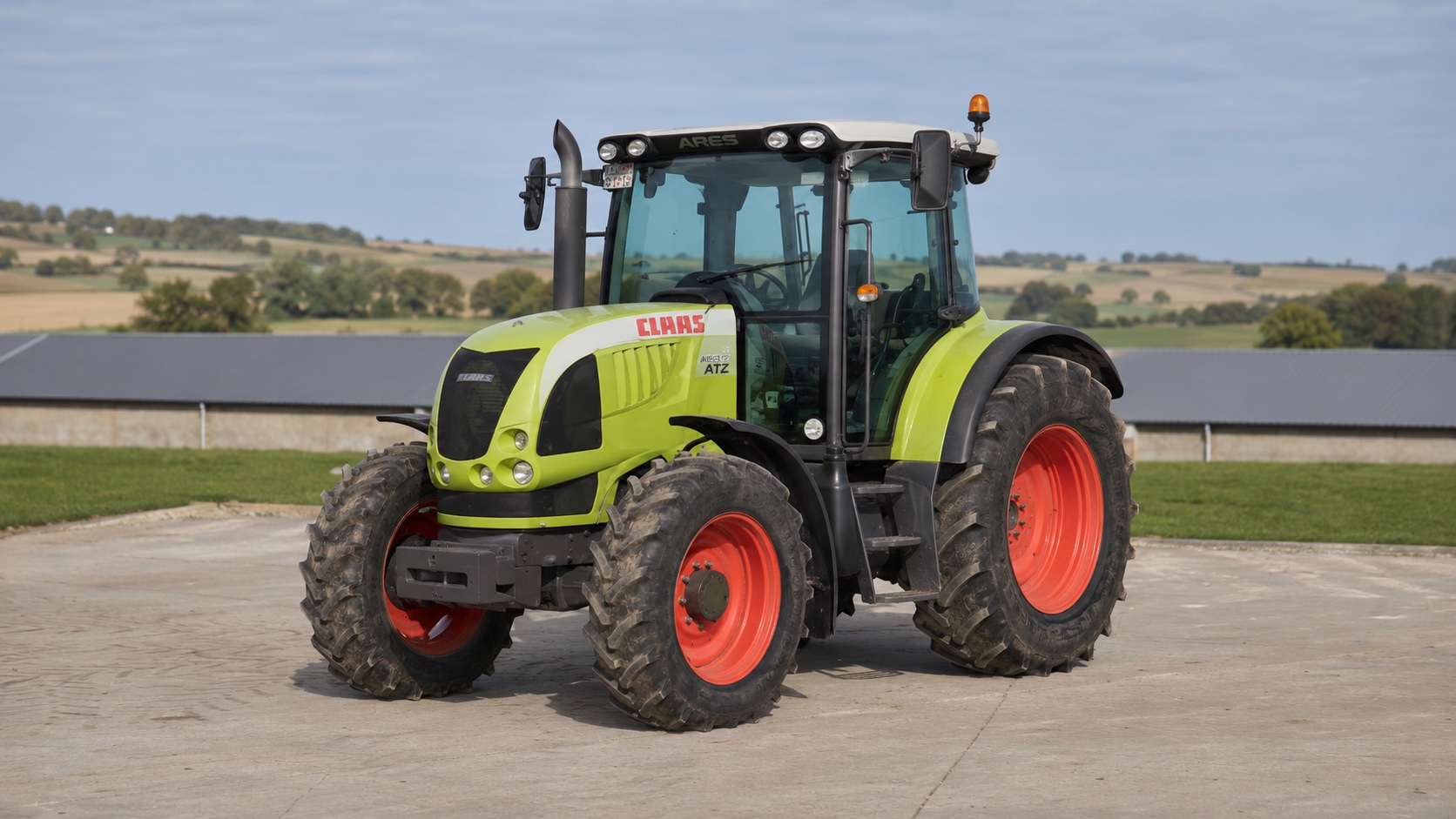 Tracteur CLAAS ARES 557 ATZ présenté dans un environnement agricole